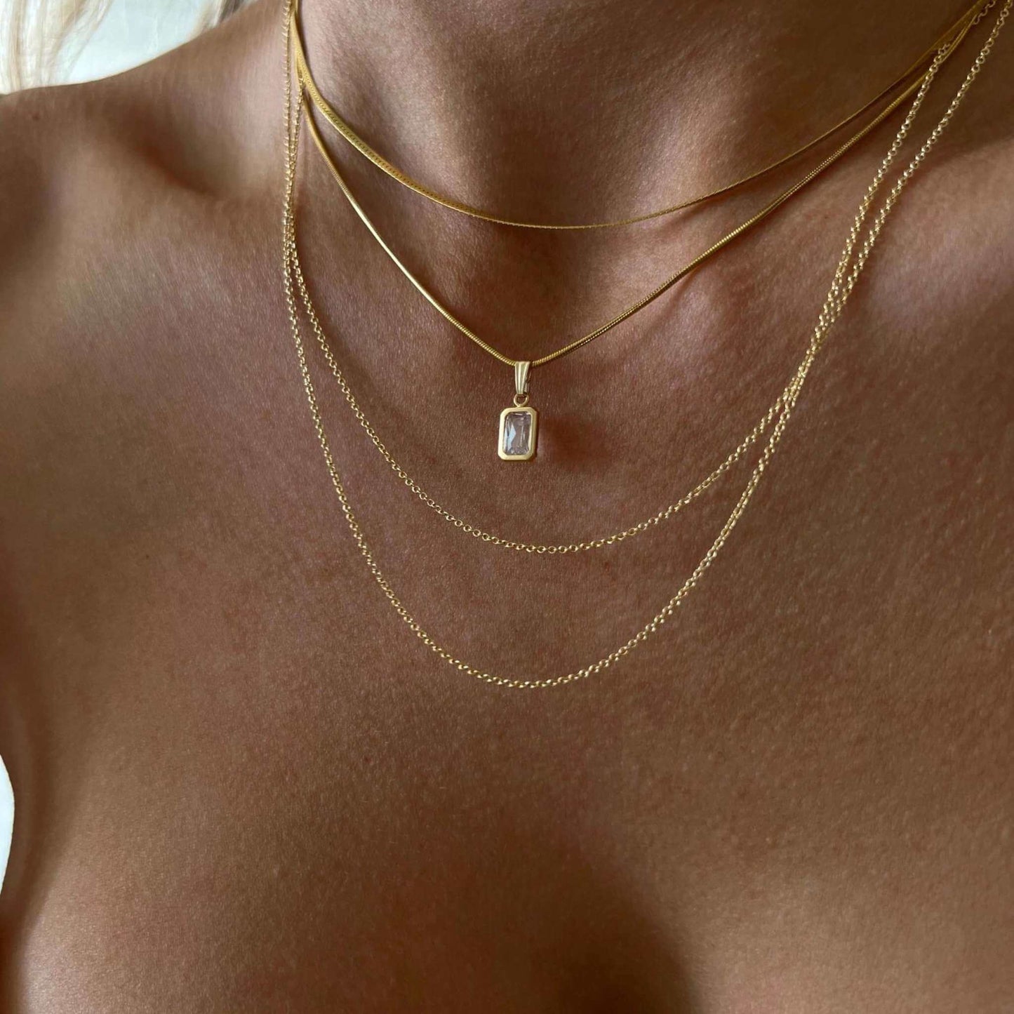 Alora 14K Gold-Filled Chain Necklace with CZ Baguette Pendant worn layered on a model's neck.