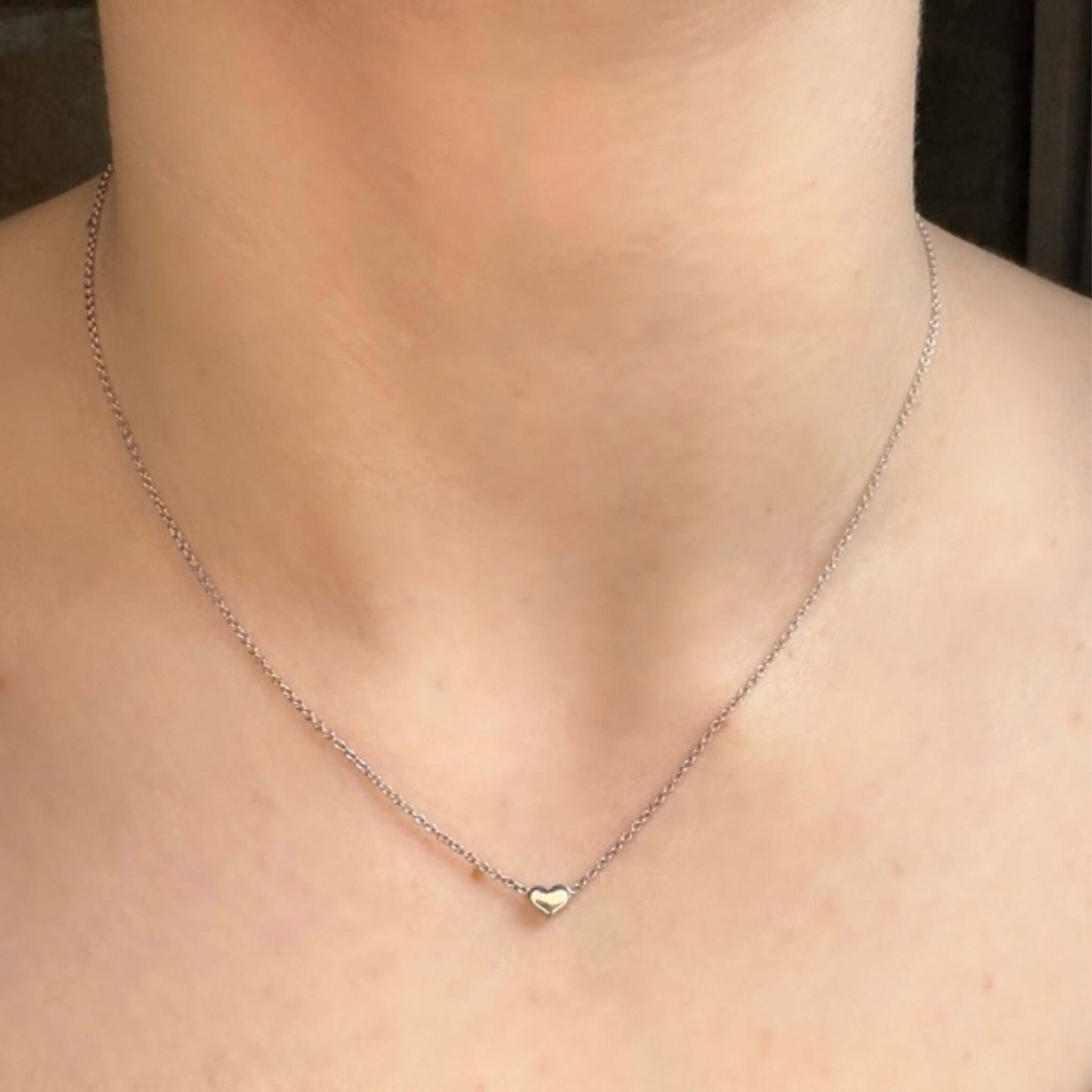 Ava .925 Sterling Silver Sliding Heart Necklace displayed on a model's neck, showcasing its delicate design and charm.