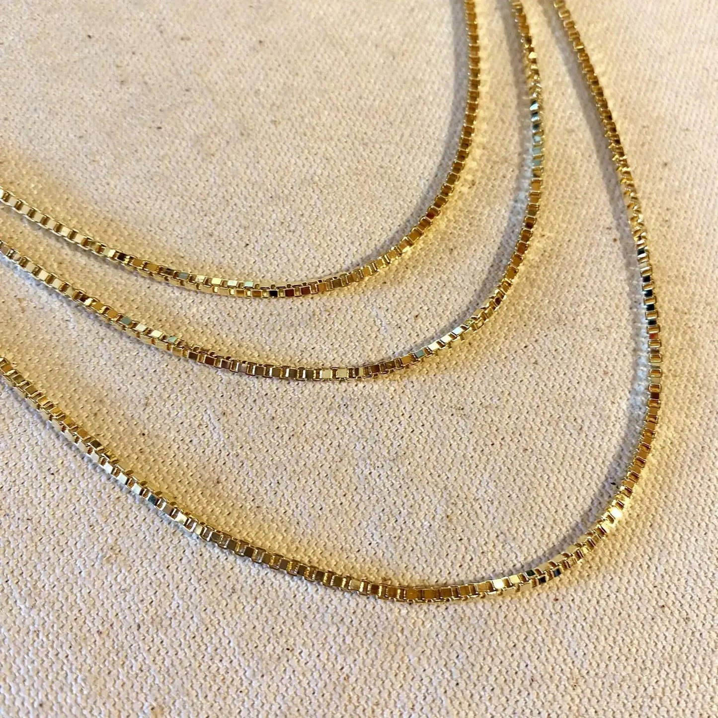 Channing 18K Gold-Filled 2mm Box Chain Necklace showcasing smooth, structured square links in a layered display.