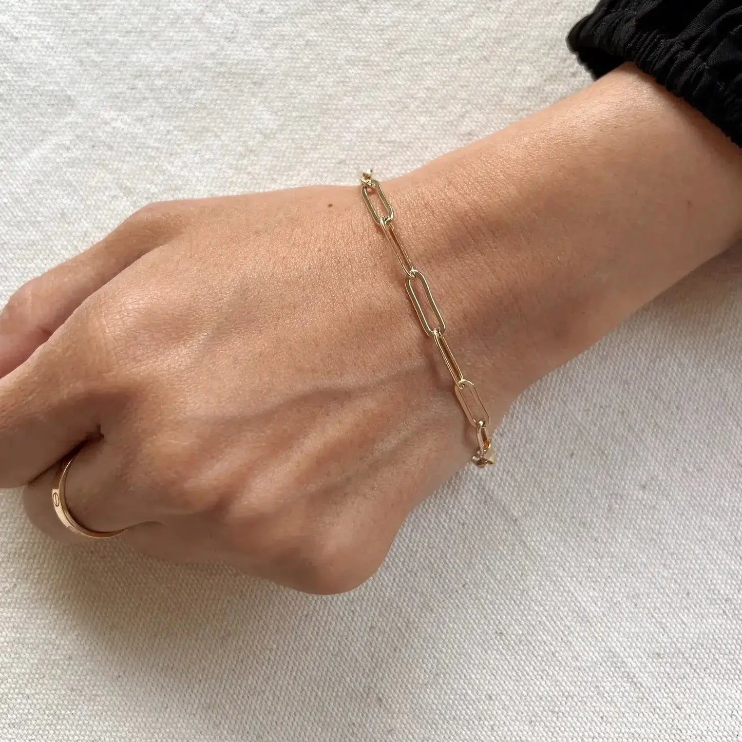 Faye Paperclip Link Bracelet worn on a hand showcasing its elegant design and subtle shine.
