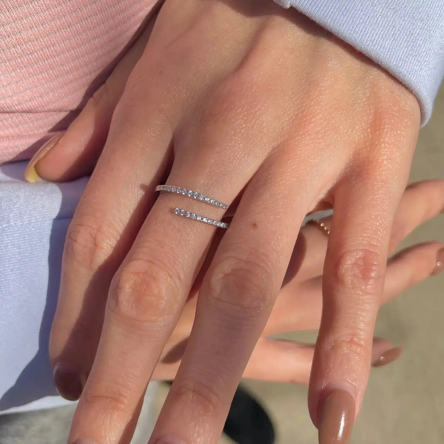 Odette Adjustable CZ Spiral Ring worn on a hand showcasing its sparkling cubic zirconia stones and adjustable design.