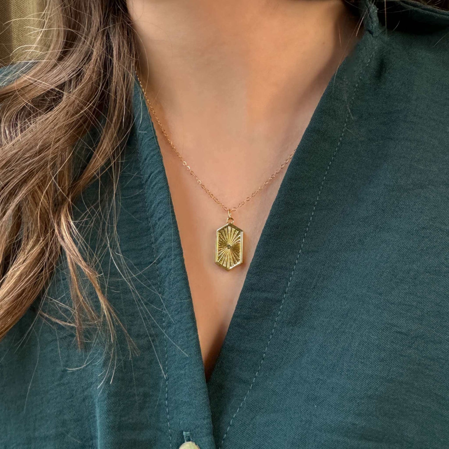 Paige 14K Gold-Filled Geometric Pendant Necklace worn by a model, featuring a hexagonal sunburst engraved pendant.