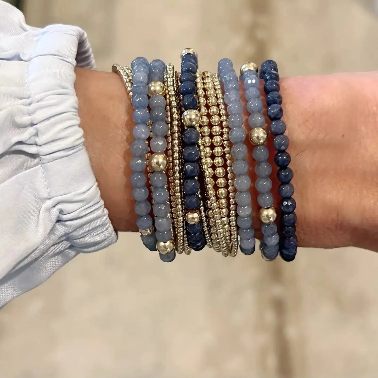 Lucy Navy Blue Stretch Bracelet stacked with coordinating bracelets featuring gold-filled accents.